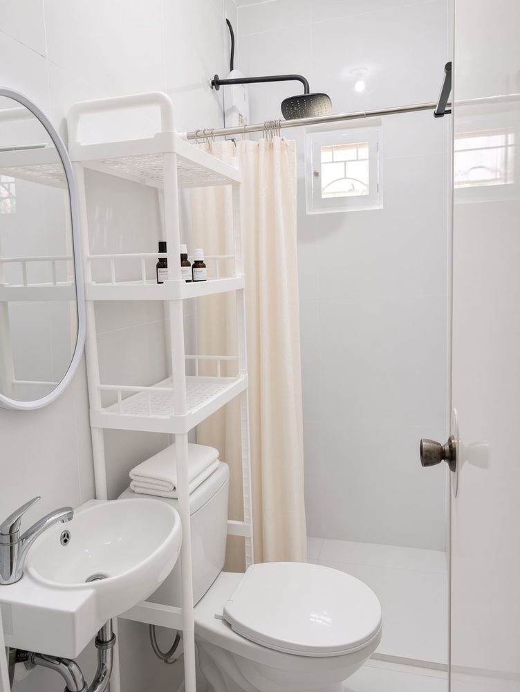 White bathroom with shower, toilet and sink